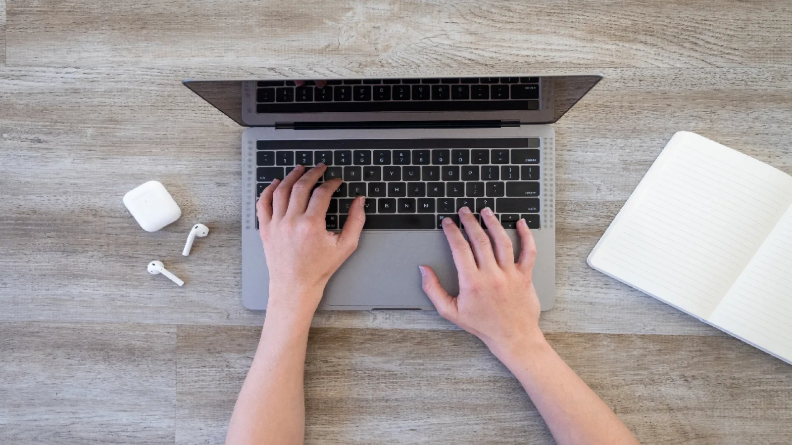 Hands typing on a laptop